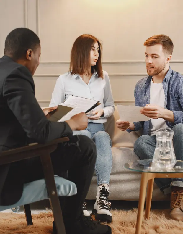 Mediator sitting with a couple at a table during a marriage mediation session